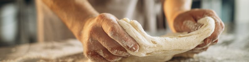 Man kneads the dough for bread